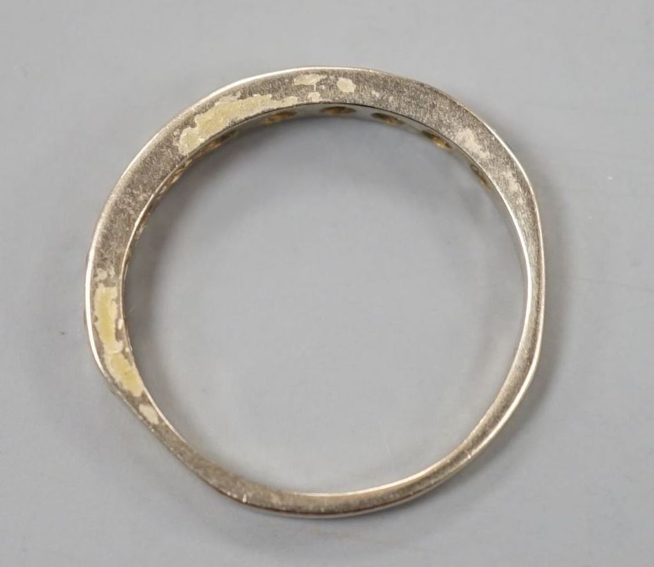 A white metal and diamond chip set half eternity ring, size K